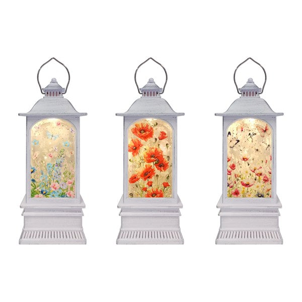 Three white lanterns with floral designs on a white background